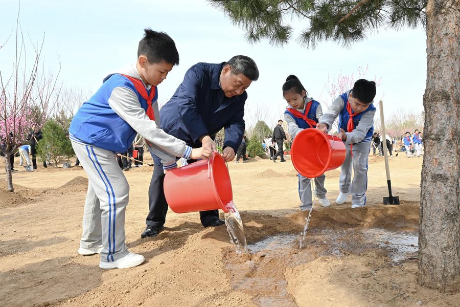 Le président Xi Jinping Waters un arbre avec des enfants lors d'une activité de plantation d'arbres volontaires dans le district de Fengtai, Pékin, Chine, 3 avril 2025. / Xinhua
