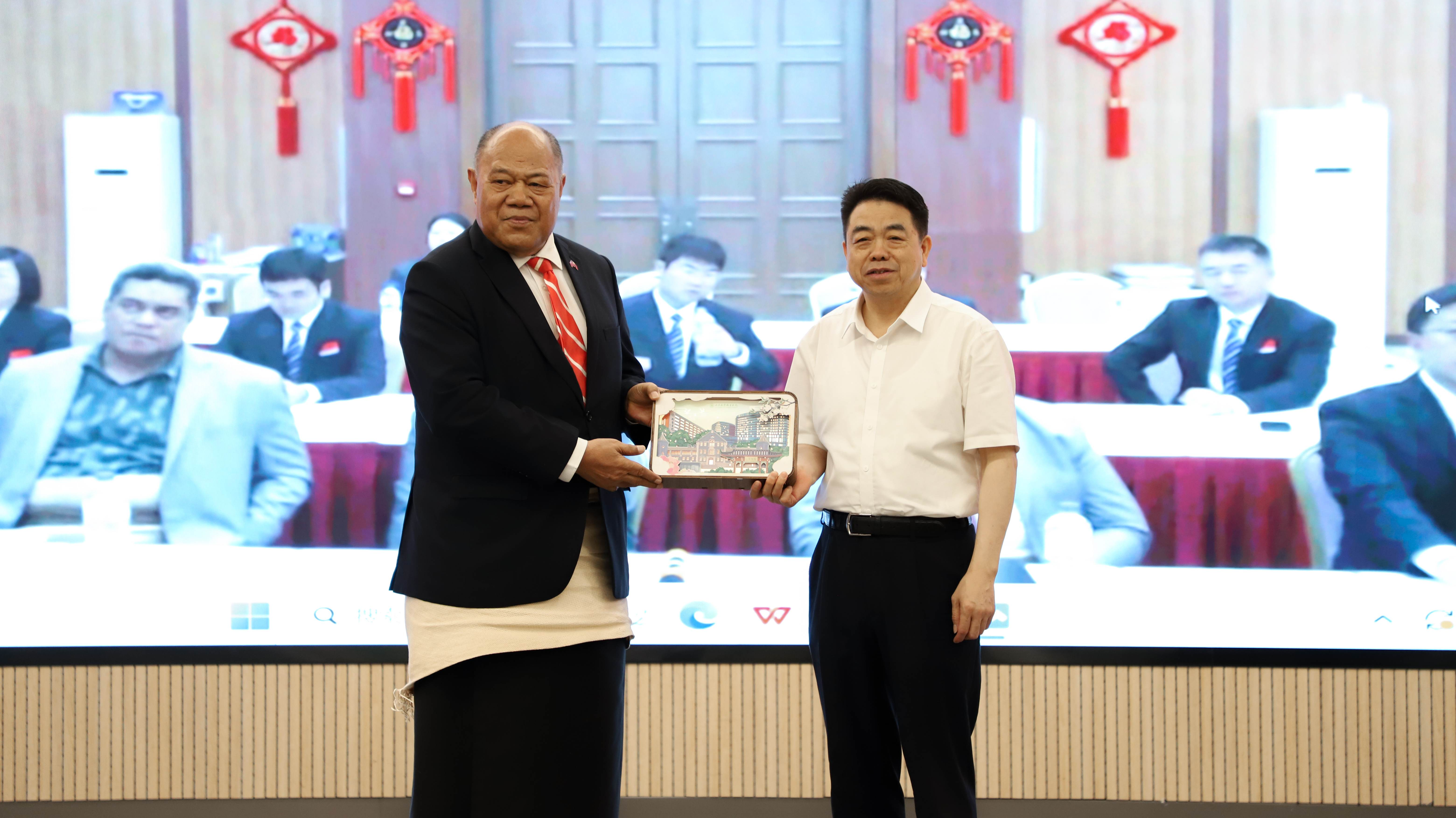 Le président de l'hôpital Qilu de l'Université du Shandong, Chen Yuguo, présente un cadeau commémoratif pour les échanges internationaux à l'ambassadeur de Tongan en Chine Tau'aika 'Uta'atu, Jinan, province du Shandong, 4 août 2025.