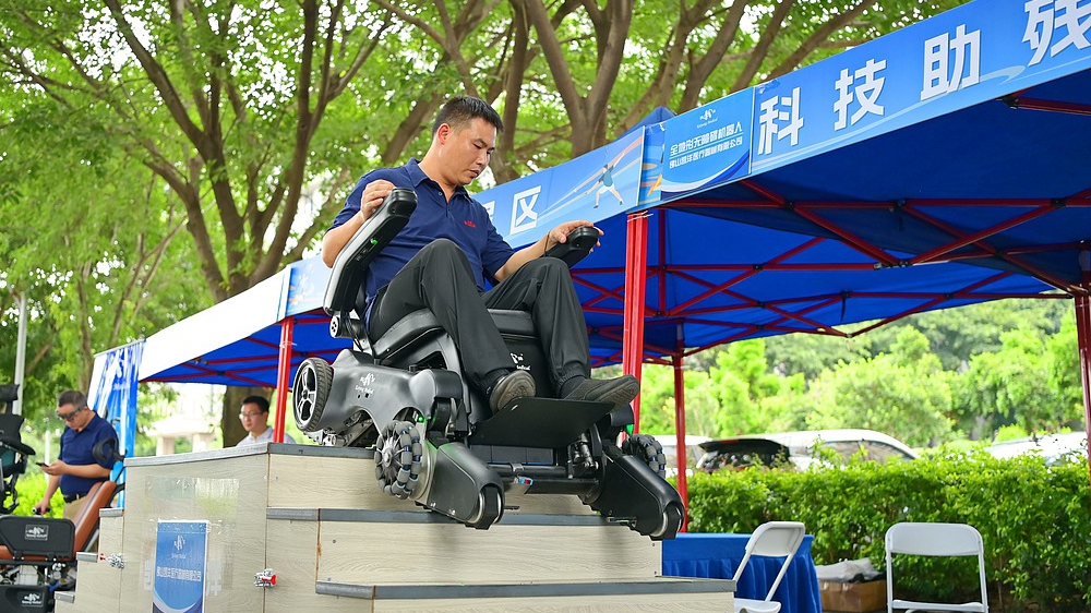 Un visiteur connaît un robot accessible d'escalier dans la ville de Ganzhou, la province du Jiangxi de la Chine orientale, 5 août 2025. / VCG