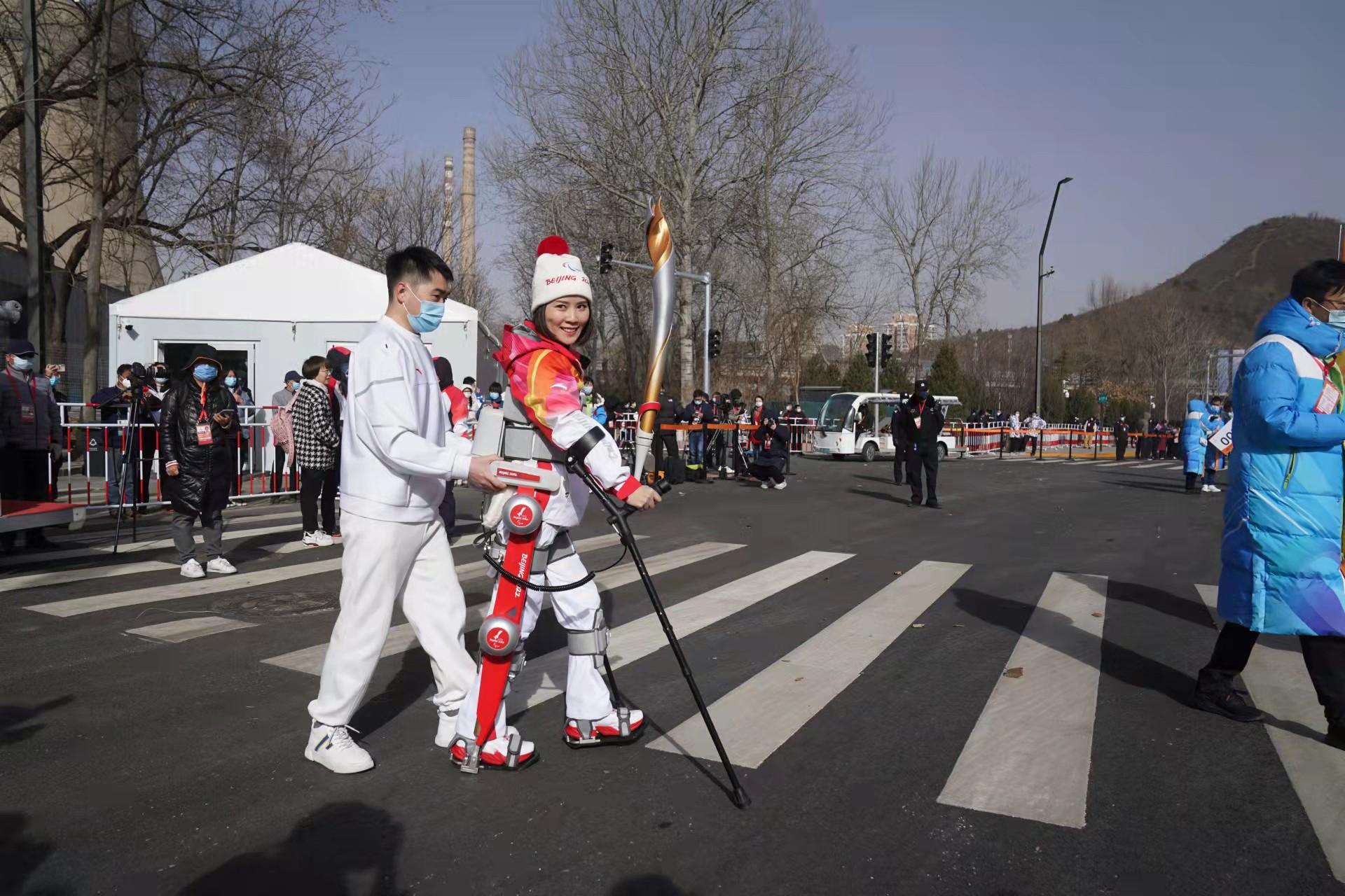 Un porte-torch pour les Jeux paralympiques d'hiver de Pékin 2022 utilise un exosquelette pour marcher debout et porter le torche, Pékin, Chine, 4 mars 2022. / Université Beihang Université Beihang