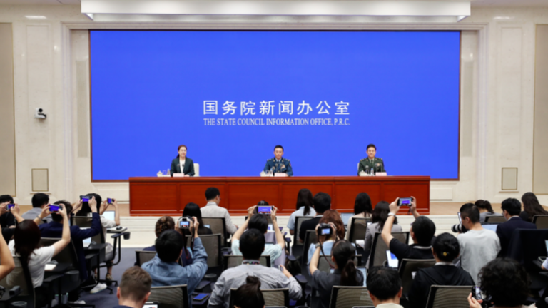 Xi Jinping pour revoir les formations de troupes alignées pendant le défilé V-Day