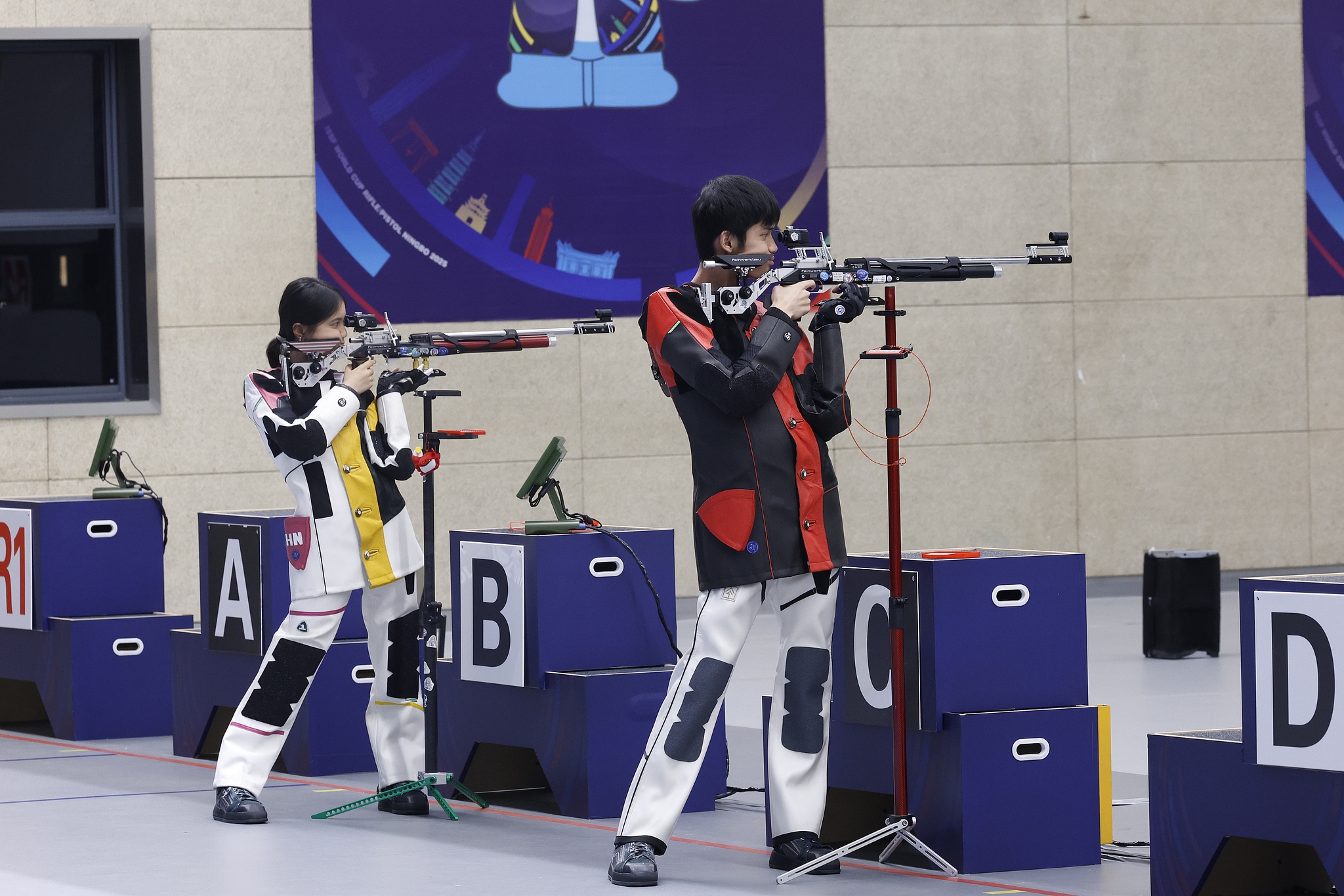 Peng Xinlu (L) et Sheng Lihao de Chine participent à l'événement d'équipe mixte de 10 mètres de fusil aérien lors de la Coupe du monde internationale de la Fédération sportive de tir (ISSF) à domicile à Ningbo, province du Zhejiang en Chine orientale, 9 septembre 2025. / VCG
