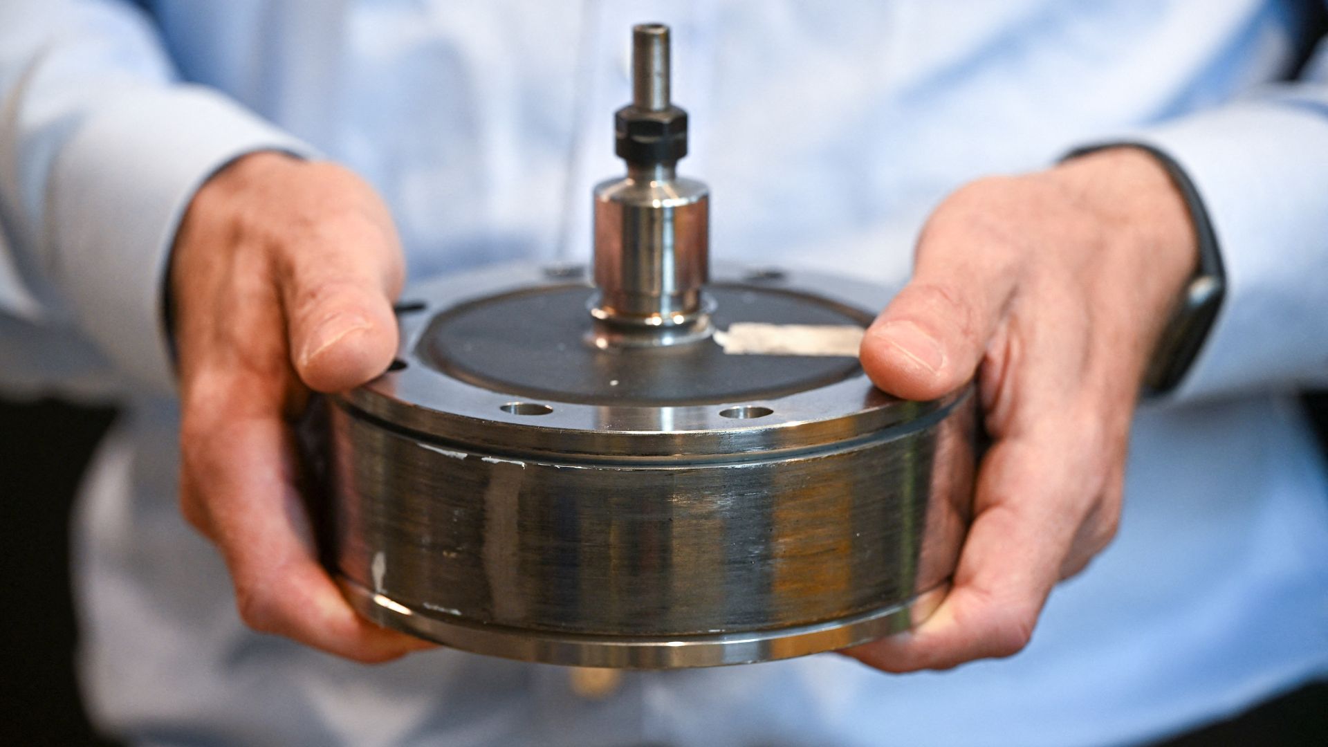 Le professeur Keith Pullen, directeur technique de Lestor, tient une rotation d'inertie du volant lors de l'atelier de Londres de la société. / Justin Tallis / AFP
