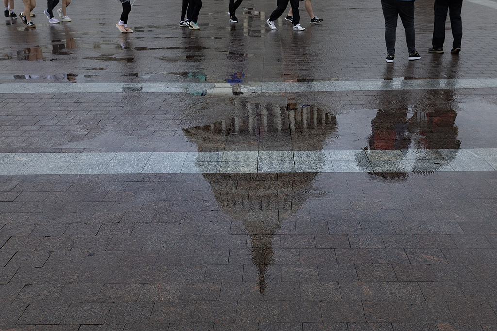 Les visiteurs traversent la Plaza East Front alors que Rain tombe à travers la colline américaine du Capitole à Washington, DC, le 13 mai 2025. / VCG