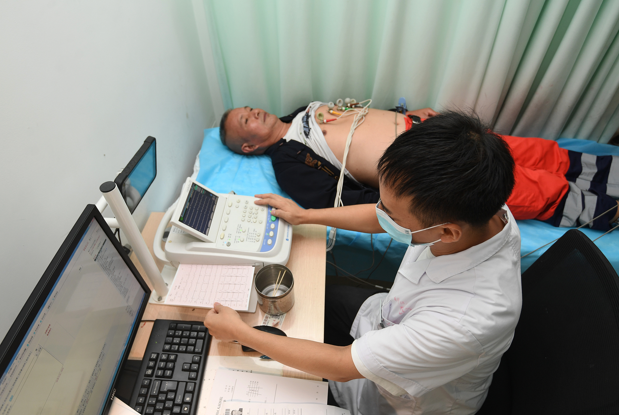 Un professionnel de la santé effectue un dépistage par électrocardiogramme d'un patient dans la ville de Guiyang, province du Guizhou, sud-ouest de la Chine, le 26 septembre 2025. /VCG