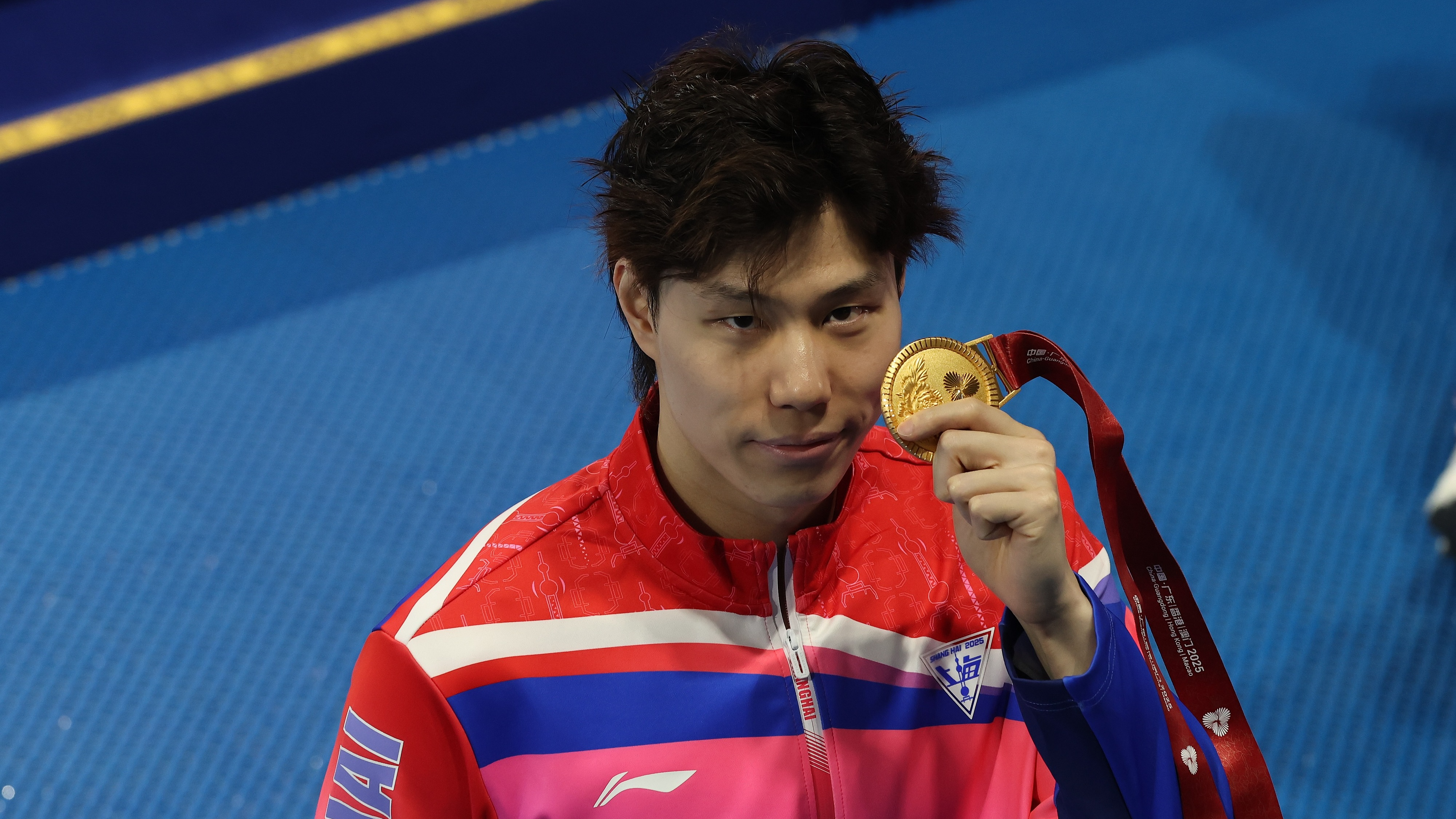 Qin Haiyang, de Shanghai, montre sa médaille d'or après avoir remporté la finale du 200 mètres brasse hommes aux 15es Jeux nationaux de Chine à Shenzhen, le 15 novembre 2025. /VCG
