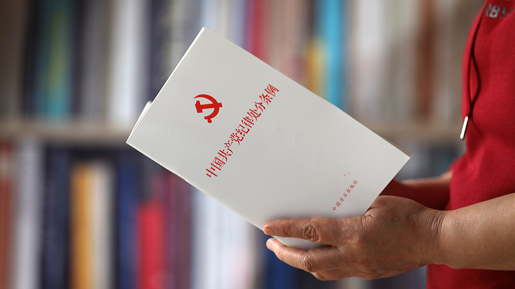 Une personne tient une copie du règlement sur les mesures disciplinaires du Parti communiste chinois (PCC) à Shanghai, en Chine, le 14 avril 2024. /VCG