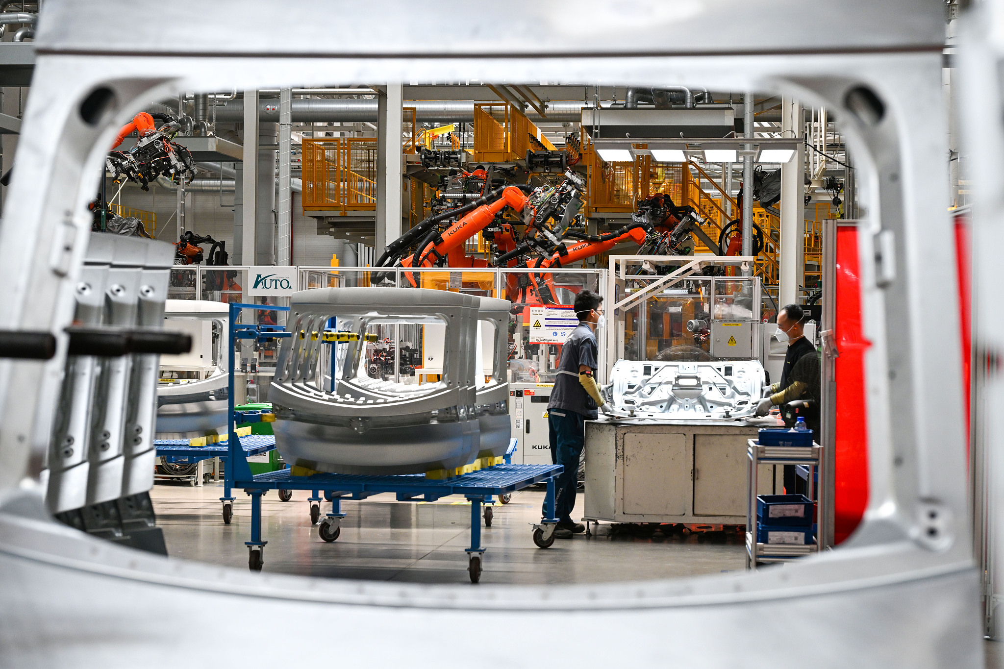 Des ouvriers industriels et des bras robotiques opéraient sur la chaîne de production de l'entreprise automobile Volkswagen (Anhui) à Hefei, province de l'Anhui, le 21 mai 2025. /VCG