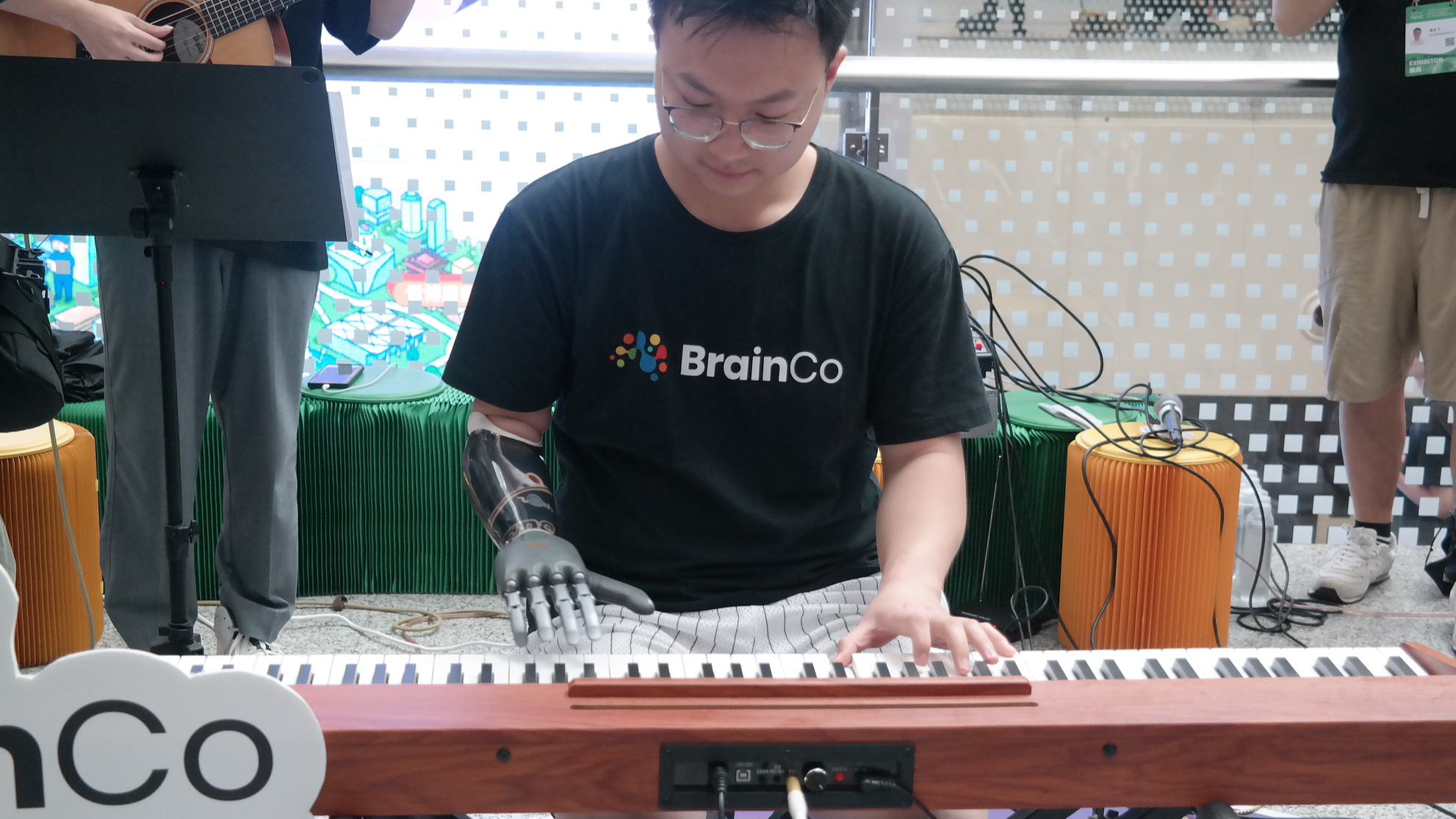 Un bras robotique alimenté par l'IA aide une personne amputée à jouer sur un clavier électronique lors de la Conférence mondiale sur l'intelligence artificielle 2025 à Shanghai, le 27 juillet 2025. /VCG