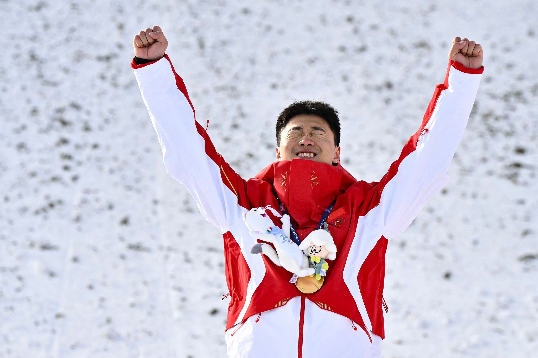 Le Chinois Wang Xindi célèbre sur le podium après avoir remporté la médaille d'or en ski acrobatique masculin aux Jeux olympiques d'hiver de Milan Cortina de 2026 à Livigno, en Italie, le 20 février 2026. /VCG