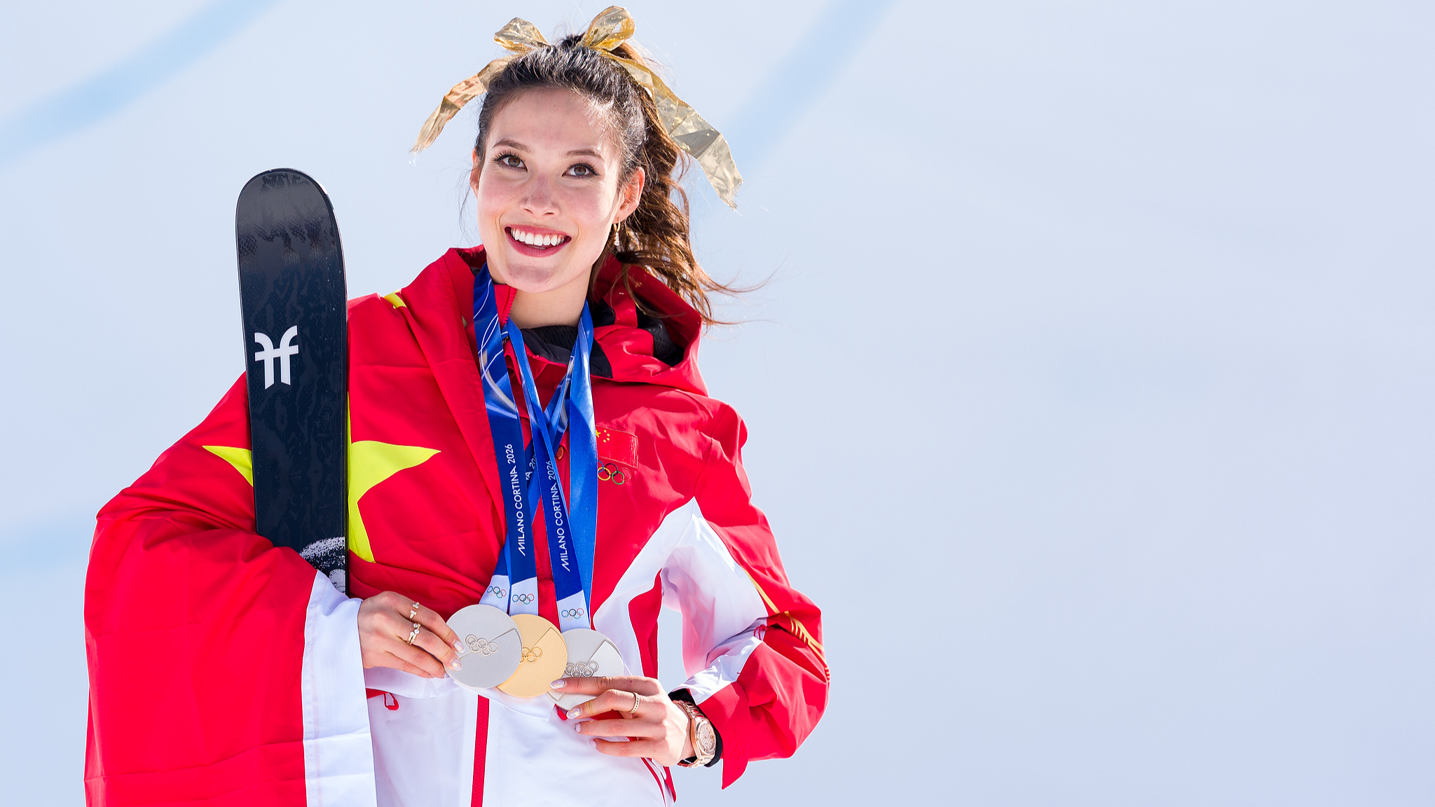 La Chinoise Gu Ailing célèbre ses trois médailles remportées dans les compétitions de Slopestyle, Big Air et Halfpipe lors de la cérémonie de remise des médailles de la finale féminine de Freeski Halfpipe aux Jeux de Milano Cortina à Livigno, Italie, le 22 février 2026. /VCG