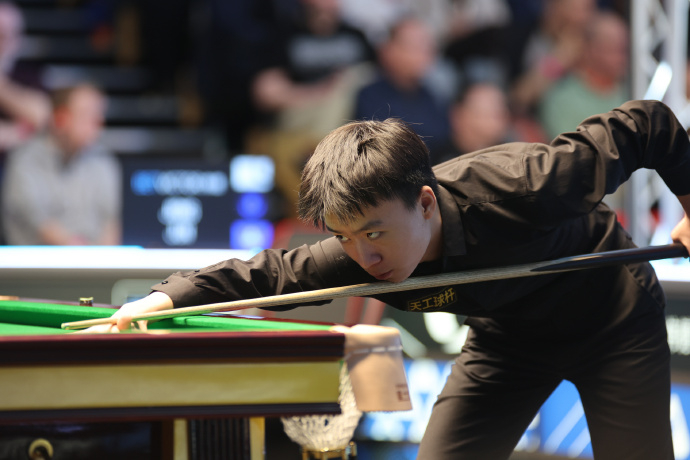 Le Chinois Jiang Jun frappe un tir contre l'Anglais Mark Selby lors d'un match de premier tour au World Snooker Tour Welsh Open au Venue Cymru à Llandudno, Pays de Galles, le 23 février 2026. /World Snooker Tour