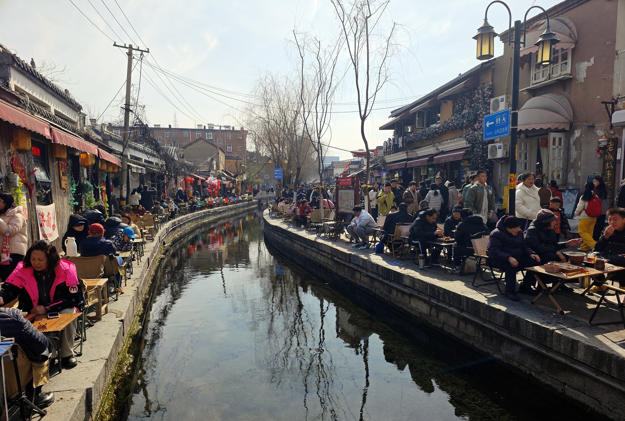 Des gens assis au bord de la rivière préparent du thé à Jinan, dans la province du Shandong (est de la Chine), le 17 février 2026. /VCG