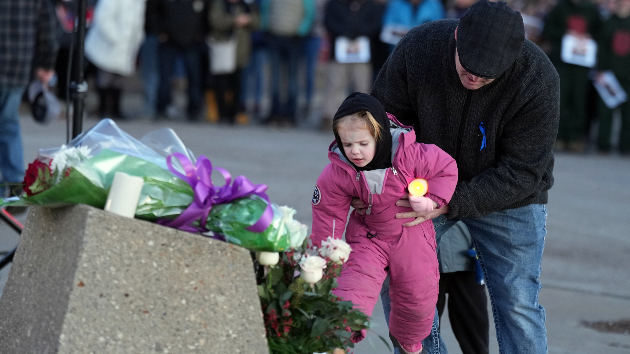 Un enfant dépose des fleurs lors d'une veillée pour les victimes d'une fusillade de masse, à Tumbler Ridge, BC, Canada, le 13 février 2026. /VCG