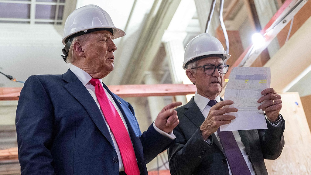 Le président américain Donald Trump montre une feuille de coûts qu'il avait remise au président de la Réserve fédérale, Jerome Powell, lors de leur visite devant la caméra dans le bâtiment en cours de rénovation de la Réserve fédérale à Washington, DC, États-Unis, le 24 juillet 2025. /VCG