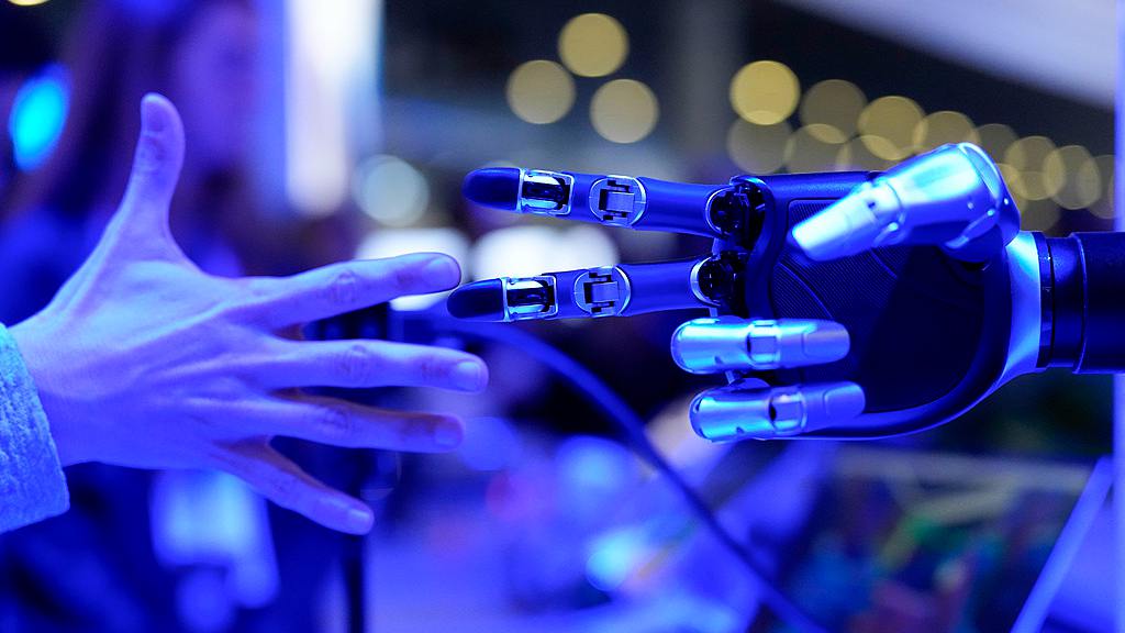 Un visiteur joue à pierre-feuille-ciseaux avec une machine sur le stand Honor lors du MWC à Barcelone, Espagne, le 2 mars 2026. /VCG