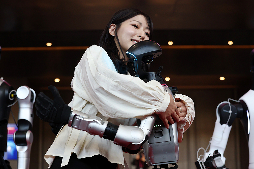 Une femme interagit avec un robot humanoïde chinois au salon Smart Factory & Automation 2026 au COEX Convention Center à Séoul, Corée du Sud, le 4 mars 2026./VCG