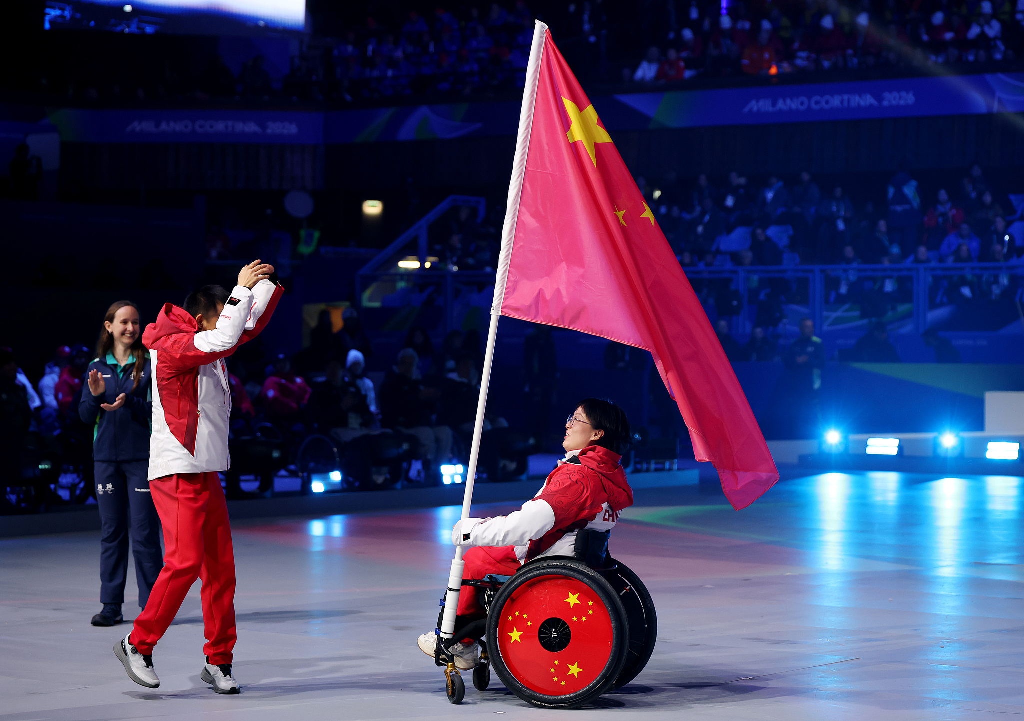 Les porte-drapeaux Cai Jiayun (à gauche) et Wang Meng, de Chine, participent à la cérémonie de clôture des Jeux paralympiques d'hiver de Milan-Cortina 2026, au stade olympique de curling de Cortina, à Cortina d'Ampezzo, en Italie, le 15 mars 2026. /VCG