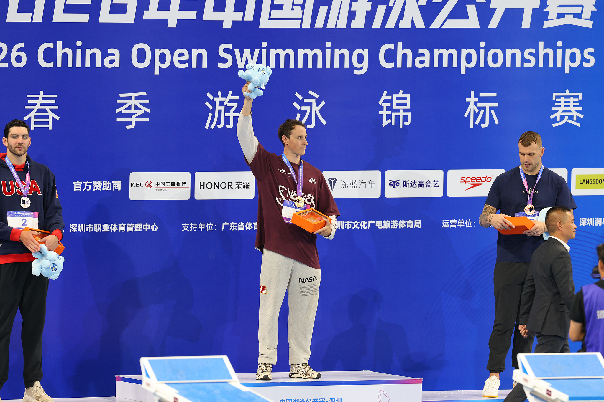L'Australien Cameron McEvoy (au centre), médaillé d'or, célèbre sur le podium après avoir remporté la finale du 50 mètres libre masculin avec un record du monde de 20,88 secondes aux Championnats ouverts de natation de Chine à Shenzhen, dans la province du Guangdong (sud de la Chine), le 20 mars 2026. /VCG