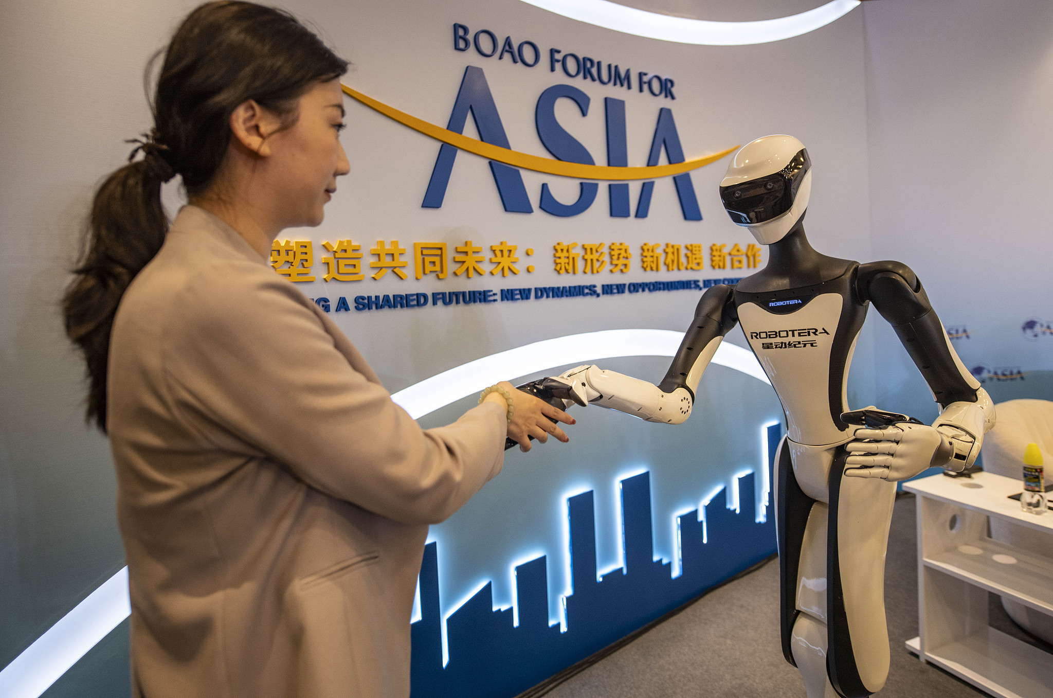 Des robots humanoïdes interagissent avec des personnes lors de la conférence annuelle du Boao Forum for Asia, le 25 mars 2026, à Boao, Hainan. /VCG