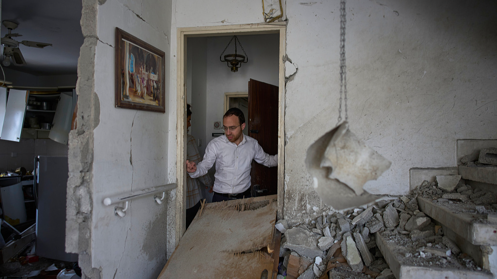 Un homme examine les dégâts causés à l'appartement de sa famille, un jour après qu'il a été frappé par un missile iranien à Bnei Brak, en Israël, le 25 mars 2026. /VCG