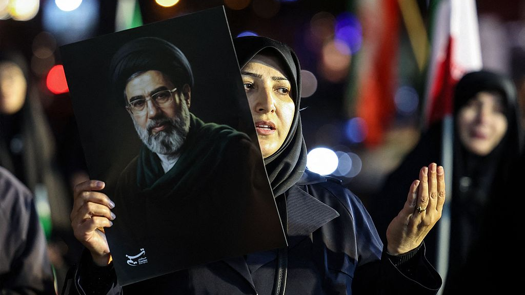 Une femme tient un portrait du guide suprême iranien Mojtaba Khamenei alors que les gens défilent en soutien aux forces armées iraniennes dans le centre de Téhéran, en Iran, le 25 mars 2026. /VCG