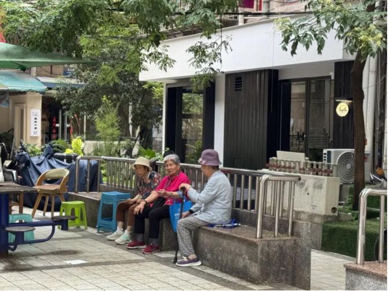 Arbres ombragés pour se rafraîchir, cafés locaux et personnes âgées discutant. /CGTN
