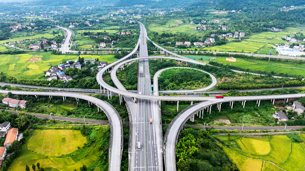 Une vue aérienne d'un échangeur à grande vitesse, d'une autoroute urbaine-rurale et d'une voie ferrée dans la province du Sichuan, en Chine, le 10 décembre 2025. / VCG