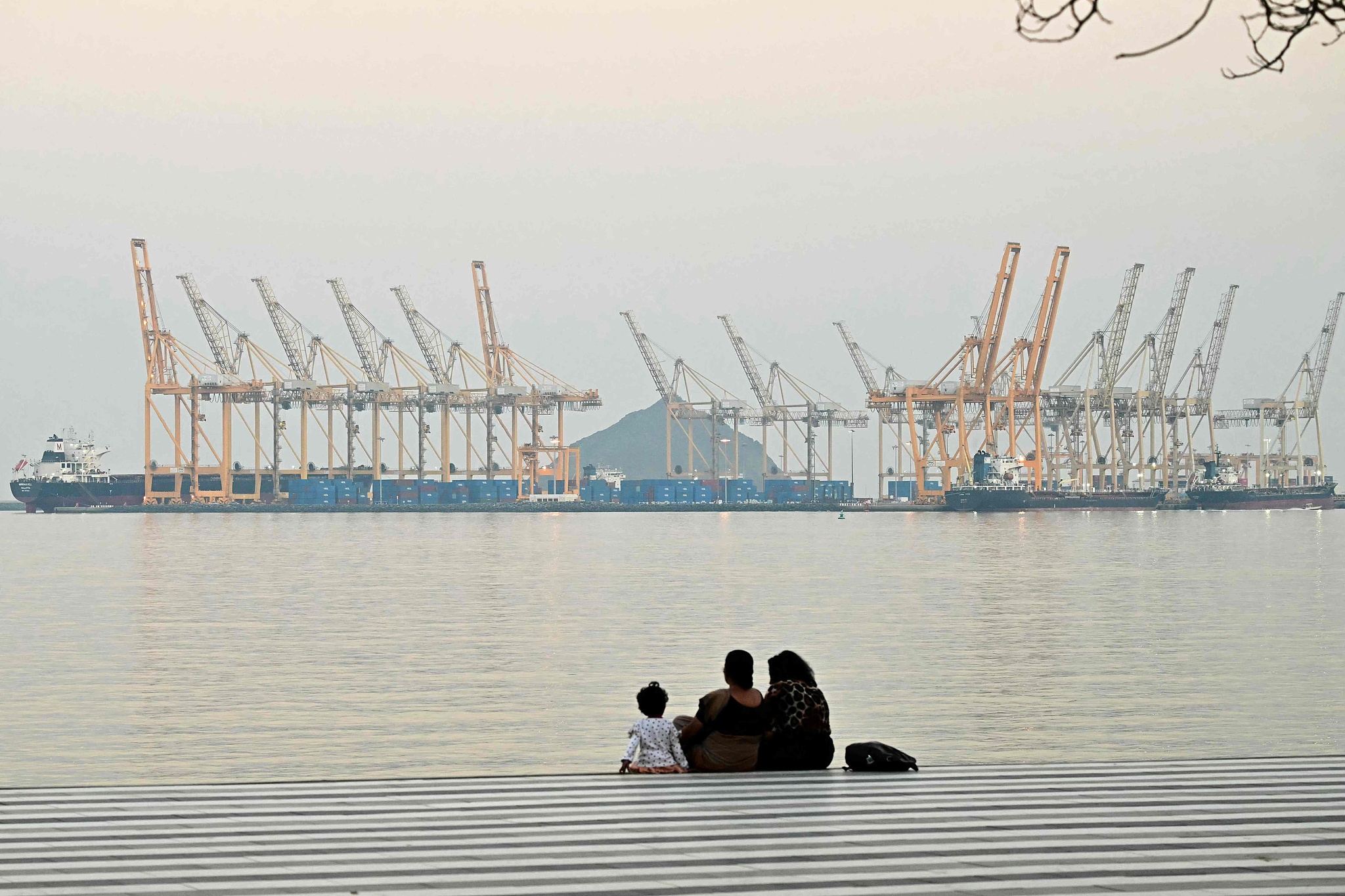 Des gens sont assis devant un chantier naval à Fujairah, dans le nord des Émirats arabes unis, le 25 février 2026. /VCG