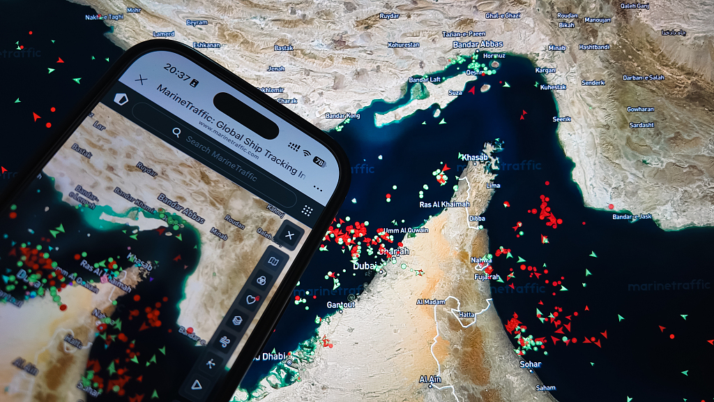 Une carte MarineTraffic montrant les mouvements des navires dans le détroit d'Ormuz s'affiche sur l'écran d'un smartphone avec une carte en arrière-plan. Selon des rapports, le trafic de navires commerciaux empruntant la principale voie de transport pétrolier a diminué dans le contexte du conflit en cours impliquant l'Iran, le 15 mars 2026. /VCG