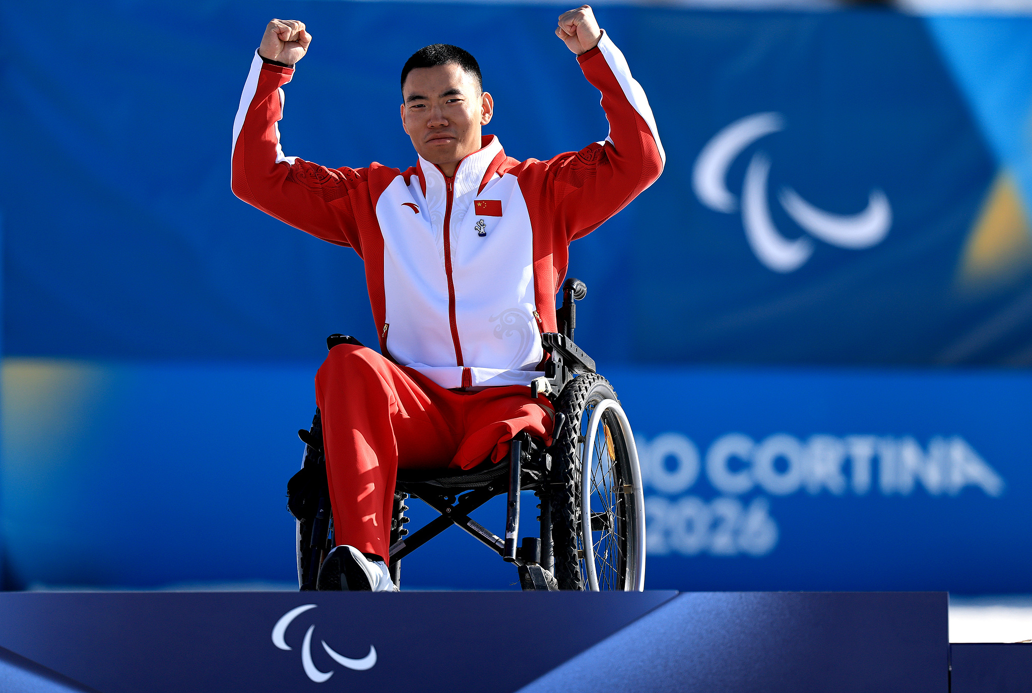 Le médaillé d'or Liu Zixu, de Chine, célèbre sur le podium lors de la cérémonie de remise des médailles de la compétition individuelle masculine de para-biathlon aux Jeux paralympiques d'hiver de Milan Cortina 2026 au stade de ski de fond de Tesero à Val di Fiemme, en Italie, le 8 mars 2026. /VCG
