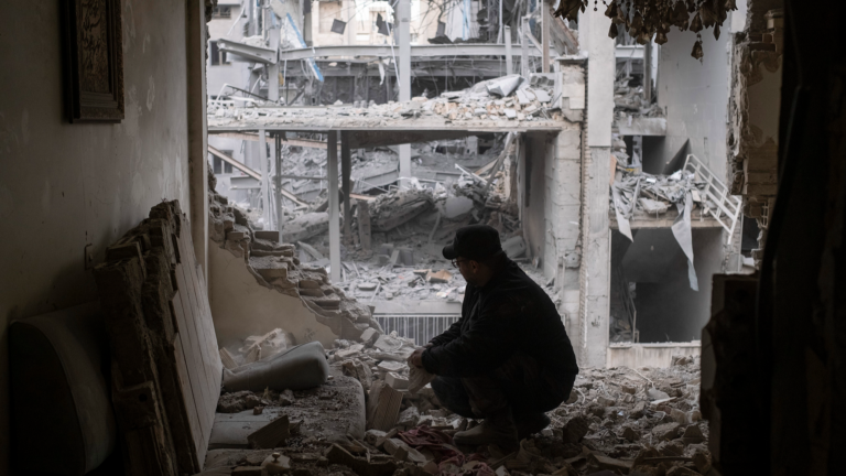 Un homme cherche ses affaires parmi les ruines de son appartement près d'un commissariat de police dans un quartier résidentiel de Téhéran, Iran, le 15 mars 2026. /VCG