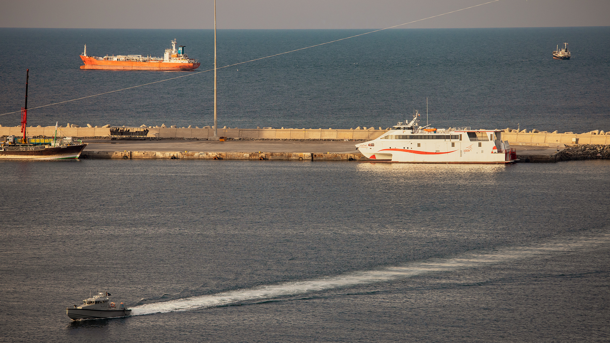 Un hors-bord de la police patrouille dans le port tandis que des pétroliers et des navires à grande vitesse sont ancrés à Mascate Anchorage, près du détroit d'Ormuz, le 30 mars 2026, à Mascate, Oman. /CFP
