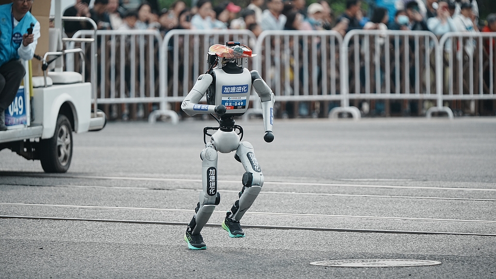 Un robot sprinte le long du parcours du semi-marathon des robots humanoïdes de Pékin, le 19 avril 2026. Plus de 100 équipes et plus de 300 robots y ont participé./VCG