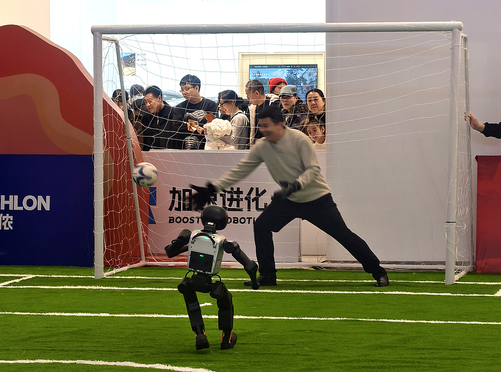 Un robot tire au but contre un gardien humain sur le terrain de football robotisé du Salon technologique du Nouvel An de Haidian à Pékin, le 20 février 2026. /VCG
