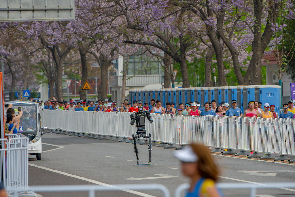 Un robot sprinte le long du parcours du semi-marathon des robots humanoïdes de Pékin, le 19 avril 2026. Plus de 100 équipes et plus de 300 robots y ont participé./VCG