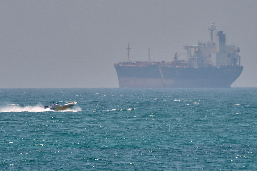 Un bateau passe devant un pétrolier ancré dans le détroit d'Ormuz, au large de l'île de Qeshm, en Iran, le 18 avril 2026. /VCG