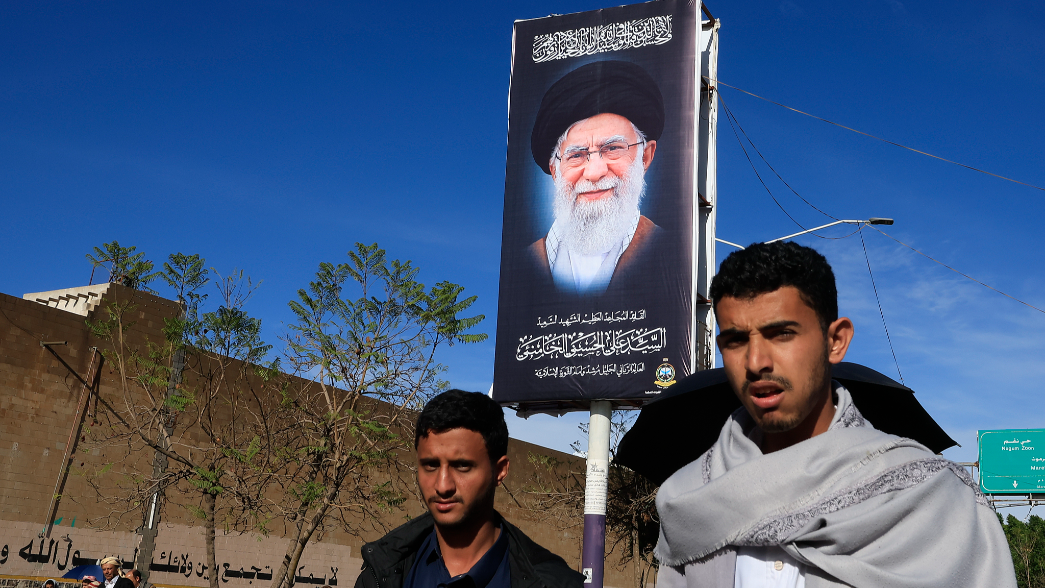 Des partisans des Houthis passent devant un panneau d'affichage représentant le défunt guide suprême iranien, l'ayatollah Ali Khamenei, dans une rue au milieu des tensions régionales à Sanaa, au Yémen, le 27 mars 2026. /VCG