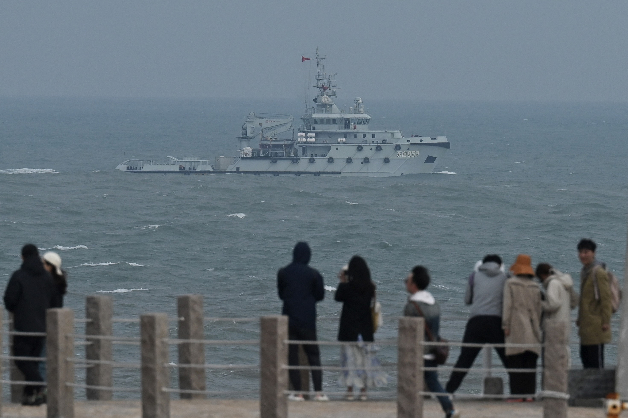 Un remorqueur de la marine chinoise navigue dans le détroit de Taiwan, devant des touristes sur l'île de Pingtan, dans la province du Fujian (sud-est), en Chine, le 7 avril 2023. /CFP