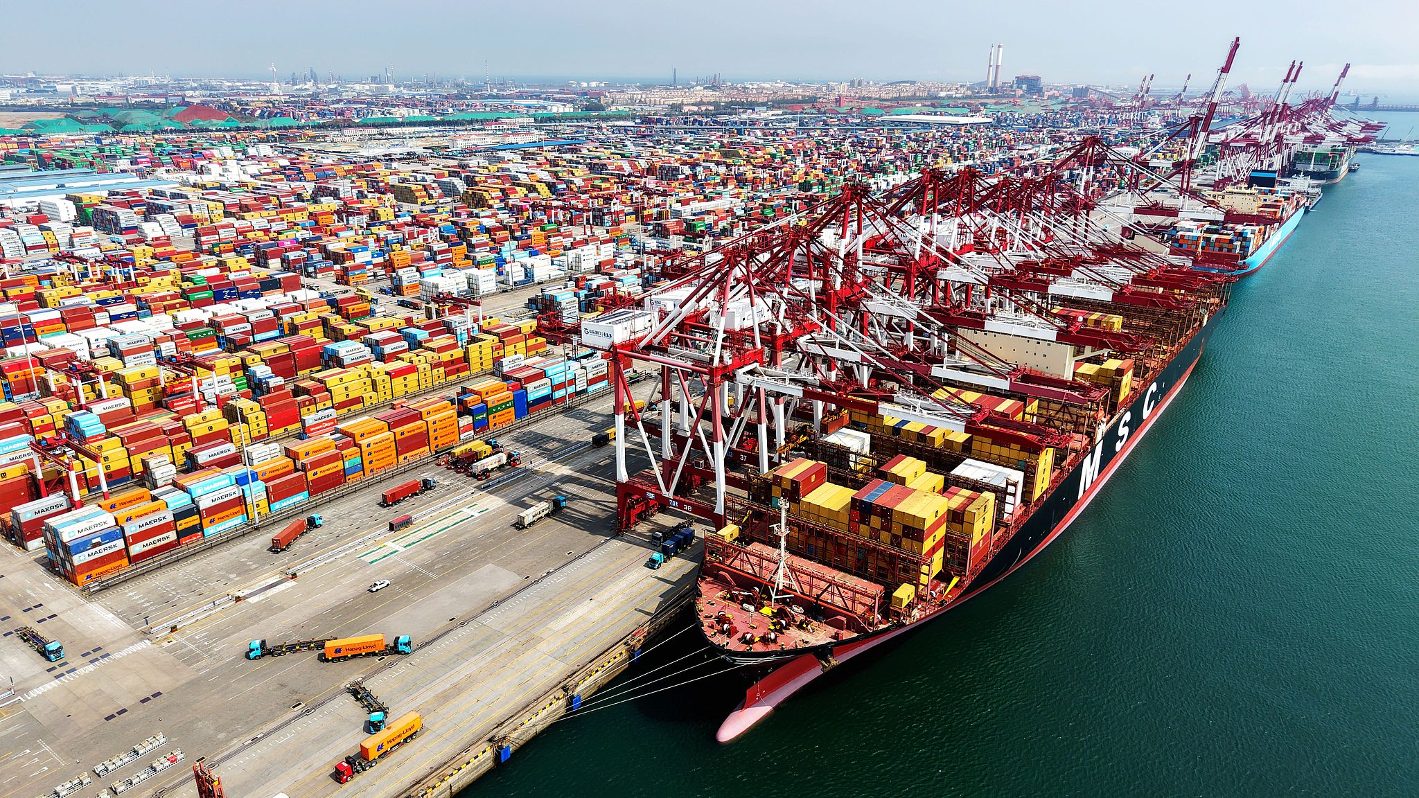 Des cargos chargent et déchargent des conteneurs de commerce extérieur au port de Qingdao, dans la province du Shandong (est de la Chine), le 18 avril 2026. /VCG