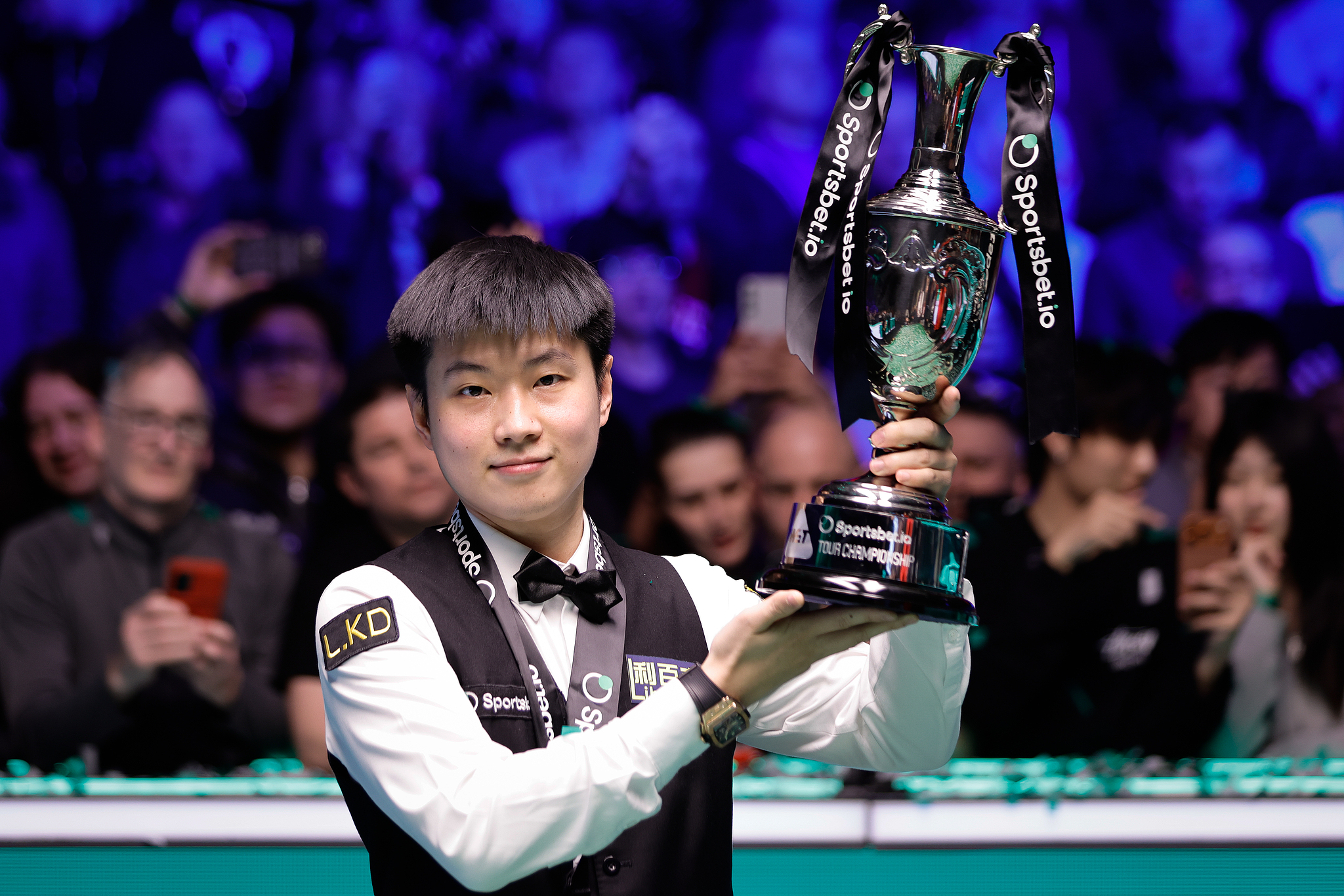 Le Chinois Zhao Xintong lève le trophée après avoir battu l'Anglais Judd Trump en finale pour remporter le titre de champion du monde du Snooker Tour à Manchester, en Angleterre, le 5 avril 2026. /VCG