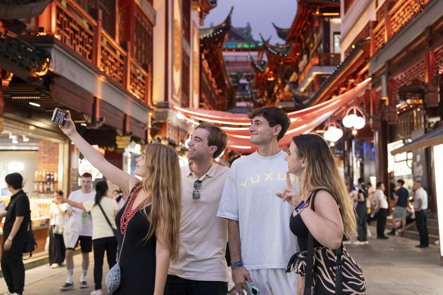 Des touristes étrangers prennent un selfie au centre commercial Yuyuan Garden à Shanghai, dans l'est de la Chine, le 21 juillet 2025. /Xinhua