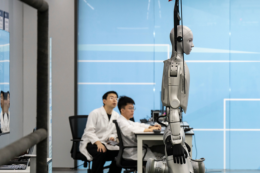 Des techniciens programment un robot humanoïde au laboratoire de robotique Guangdong Power Grid Co. de China Southern Power Grid Co., dans la province de Guangzhou, en Chine, le jeudi 16 avril 2026. /VCG
