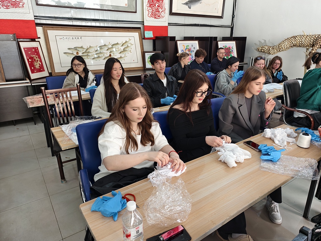 Des étudiants internationaux russes participent à un atelier traditionnel de tie-dye à l'Université Heihe, dans la province du Heilongjiang, le 12 mai 2025. /VCG
