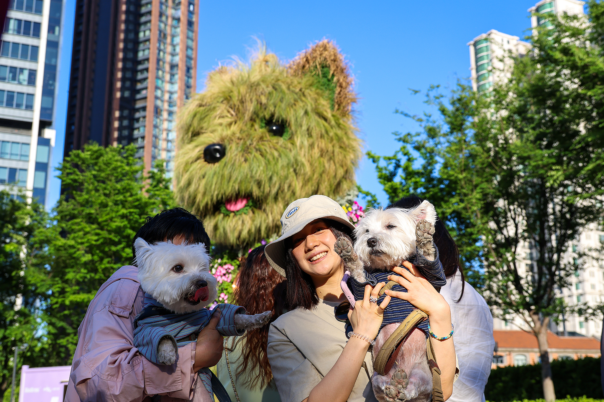 Les visiteurs posent pour des photos avec leurs chiens de compagnie devant le