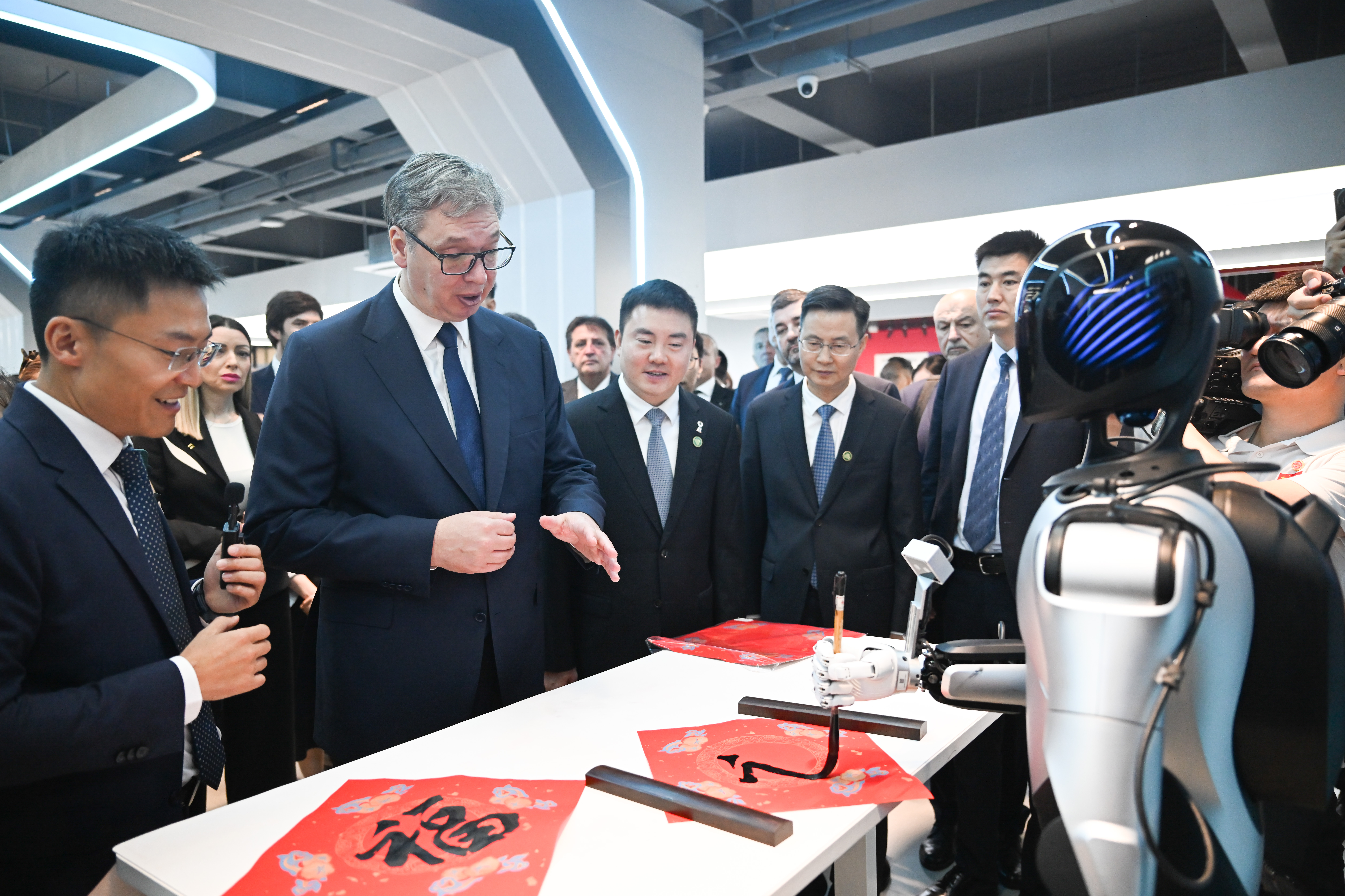 Le président serbe Aleksandar Vucic regarde un robot écrire le caractère chinois 