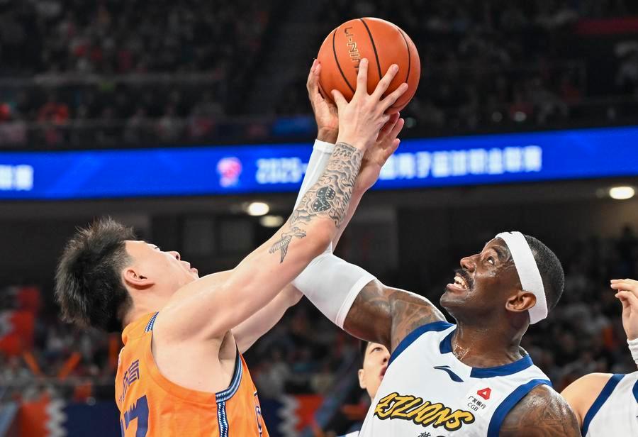 Zhang Zhenlin (à gauche), des Sharks de Shanghai, concourt pour le ballon lors du premier match de la finale de la CBA contre les Lions de Guangsha, dans la municipalité de Shanghai (est de la Chine), le 26 mai 2026. /Xinhua