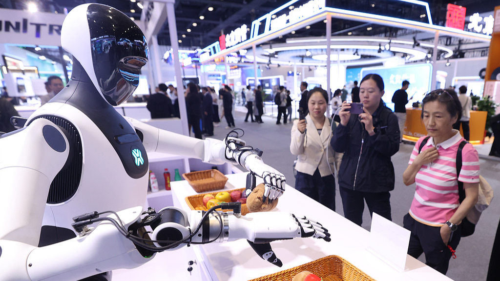 Des visiteurs regardent un robot ramasser des objets lors de la 28e Exposition internationale de haute technologie de Chine à Pékin, à Pékin, le 8 mai 2026. /VCG
