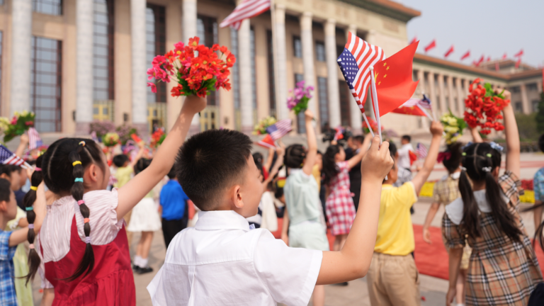 Des enfants brandissent des fleurs et des drapeaux chinois et américains au Grand Palais du Peuple à Pékin, en Chine, le 14 mai 2026. /VCG
