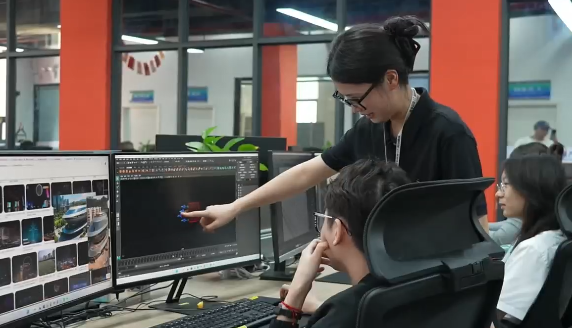 Yang Dan (au centre), planificatrice de vols d'essaims de drones, discute de son travail avec son équipe dans la ville de Nanning, dans la région autonome Zhuang du Guangxi en Chine. /CMG